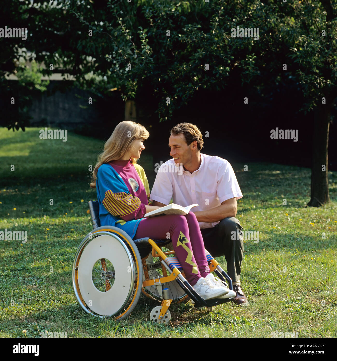 Behinderte Frau im Rollstuhl und Mann im Garten Stockfoto