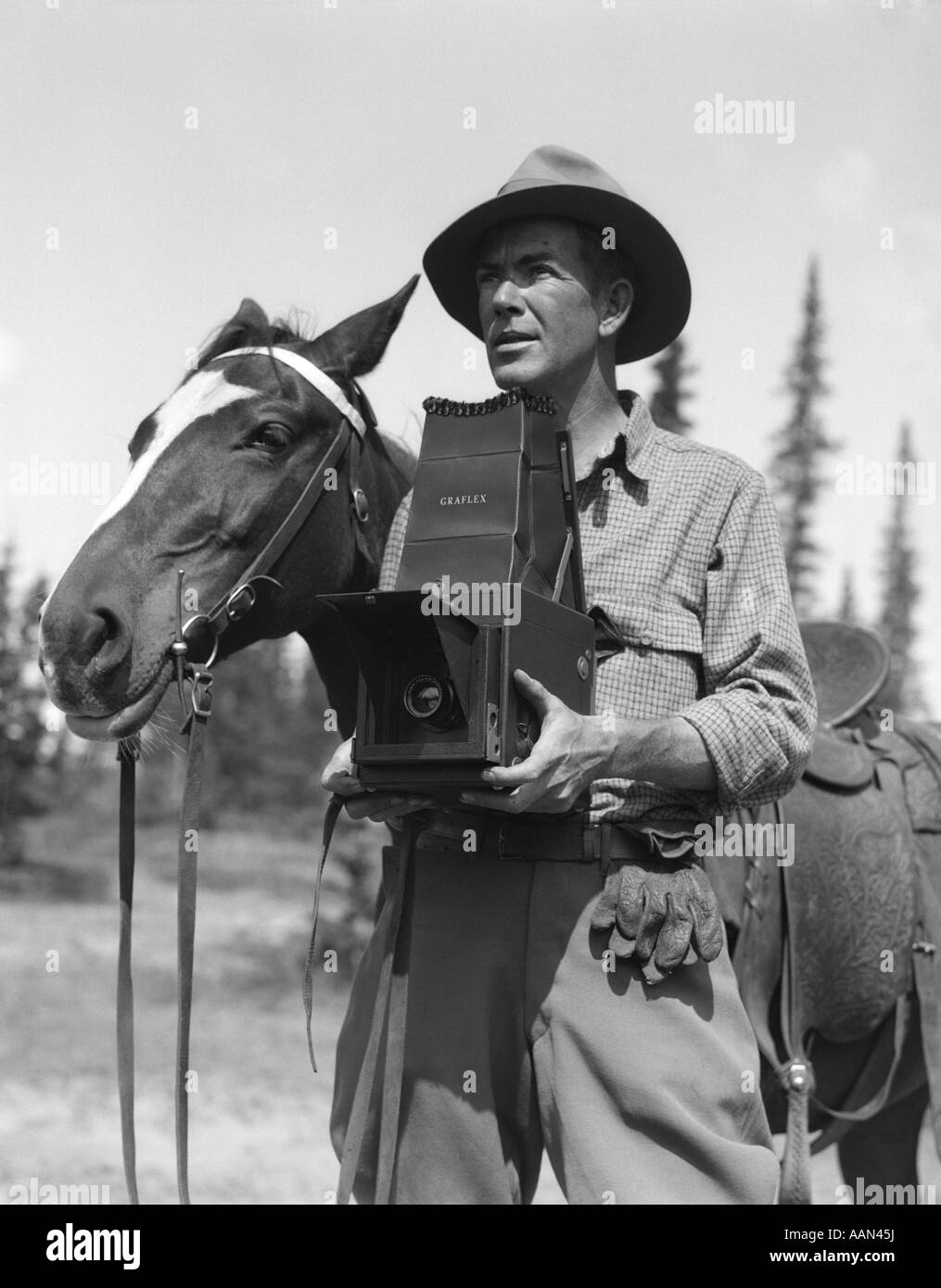 1920S 1930S GESATTELT MANN FOTOGRAF IN FEDORA & REITHOSE GRAFLEX KAMERA NEBEN PFERD Stockfoto