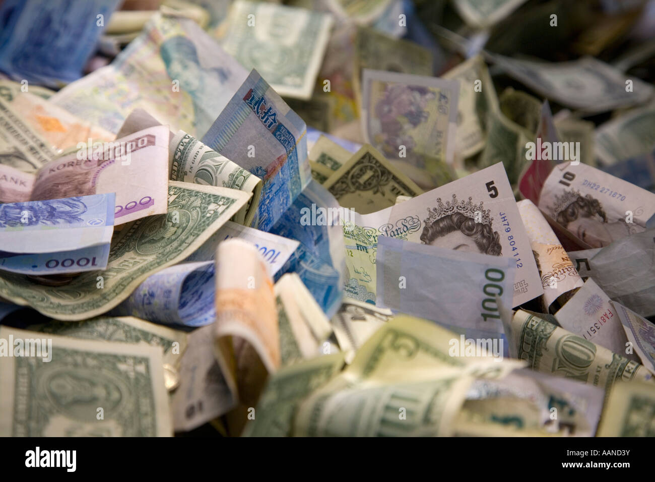 Banknoten aus mehreren Ländern in eine Spendenbox im British Museum London England Stockfoto