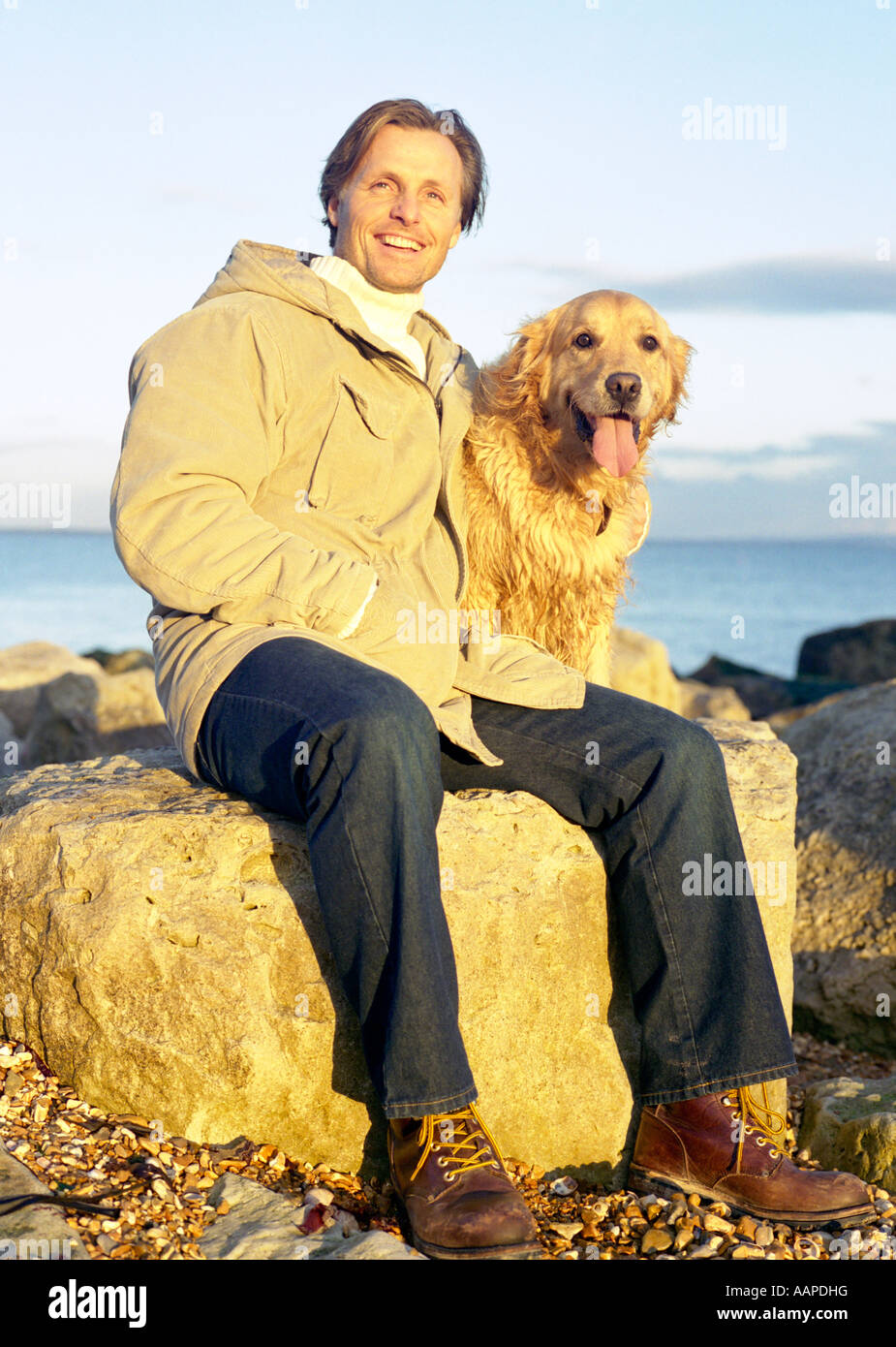 Mann mit Hund am Strand. Stockfoto
