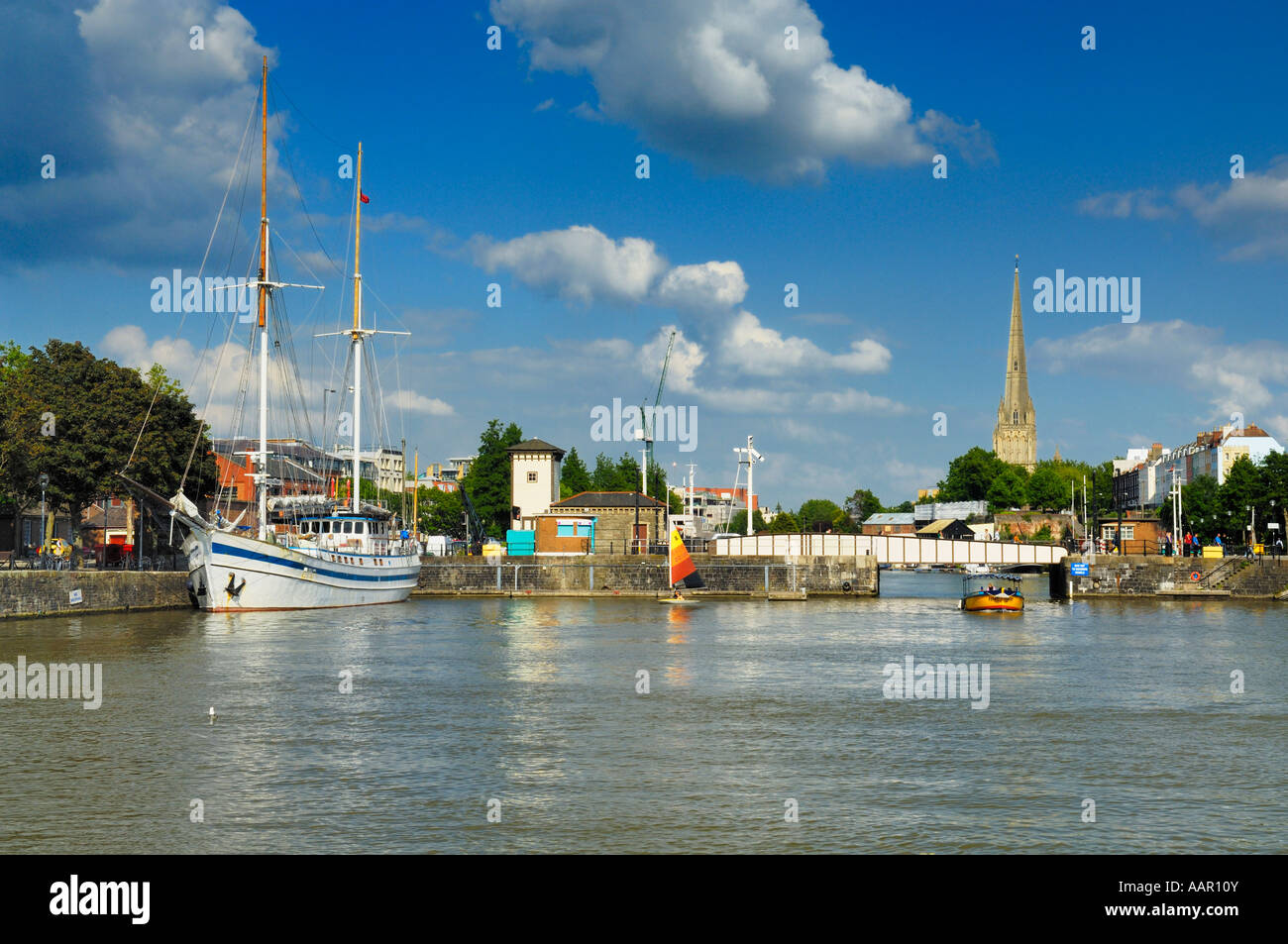 Die Schwimmenden Hafen im Princes Wharf in der Stadt Bristol, England. Die alten Eisen Prince Street Swing Bridge und der St. Marys Redcliffe Kirche kann in der Ferne zu sehen ist. Stockfoto
