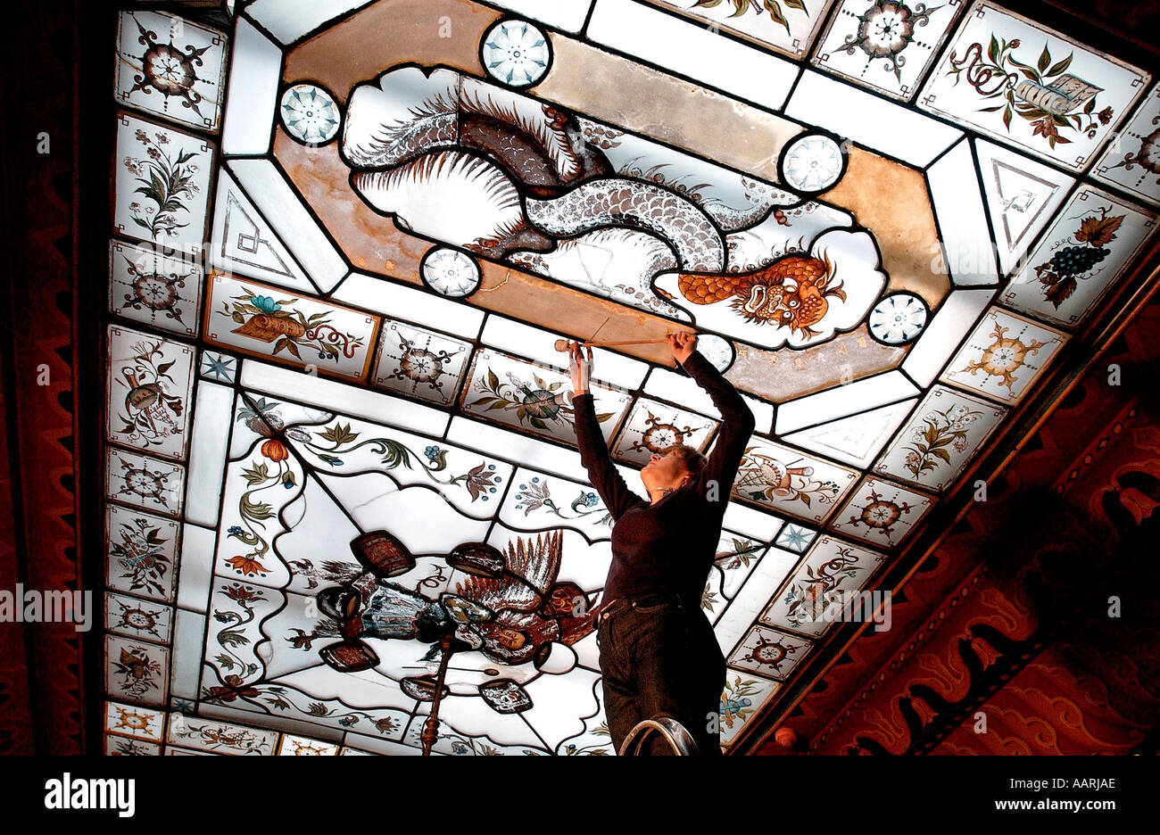 Ein Frau-Restaurator Arbeiten zur Erhaltung der Hand gemalt orientalischen Stil Glas der Royal Pavillon-Brighton Stockfoto