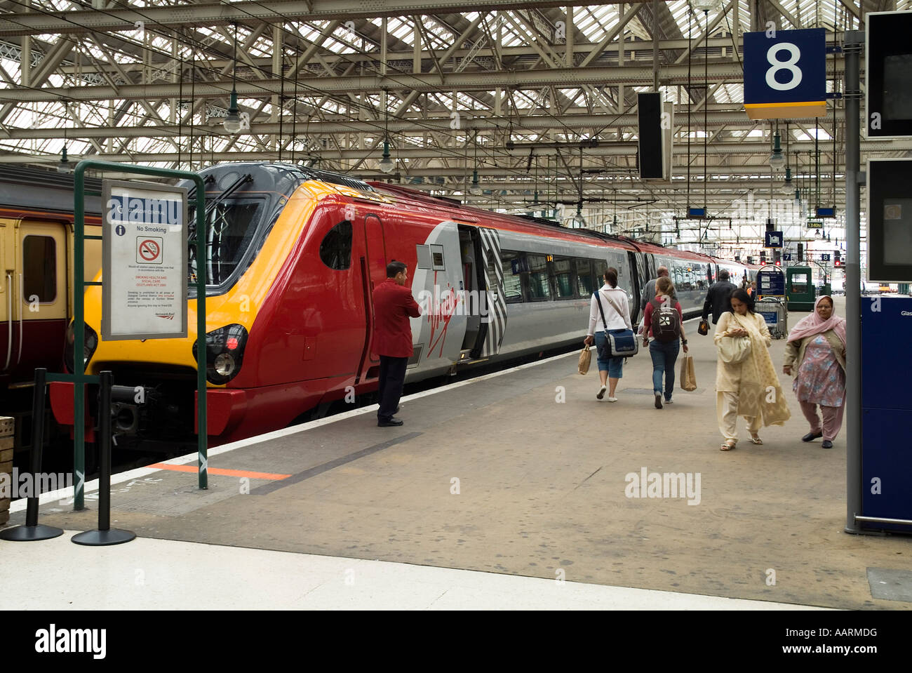 dh HAUPTBAHNHOF GLASGOW Passagiere, die auf dem Bahnsteig zu und gehen Von Virgin Trains Personenzug Stockfoto