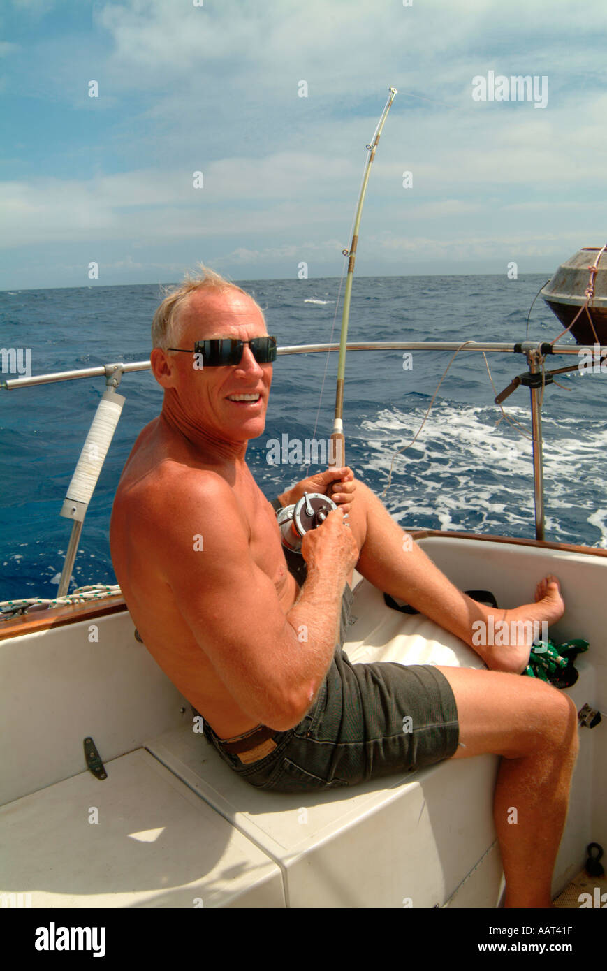 Ein Mann von einem Segelboot auf dem Weg über einen Ozean Fischen Stockfoto