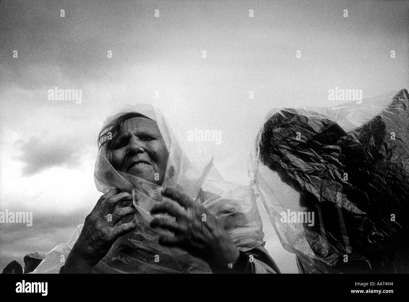 Babushkas Schutz vor dem Regen bei einer Pilgerfahrt indem man Plastiktüten über ihre Köpfe hinweg Stockfoto