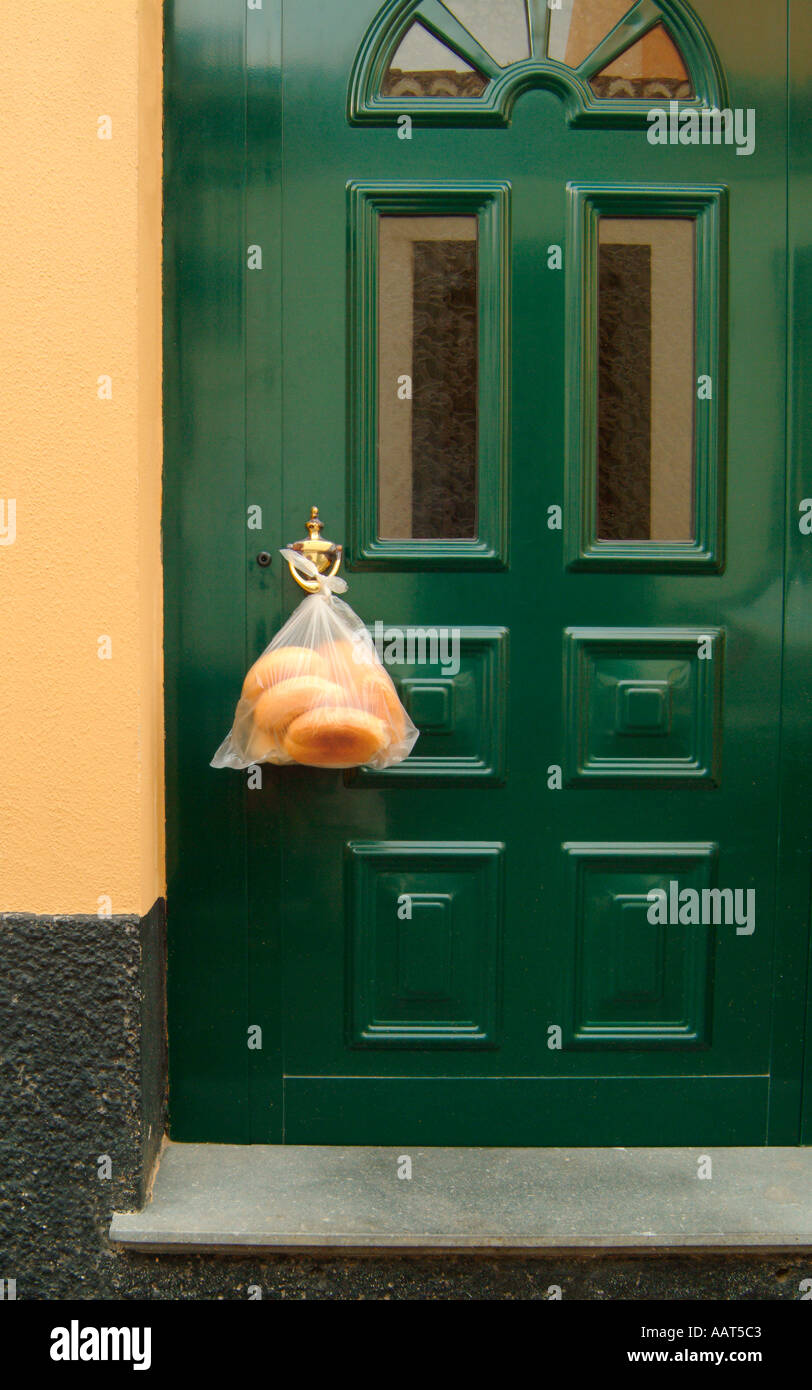 Eine Tür in einer Wohngegend mit gelieferte Brot hängen von den Knopf. Stockfoto