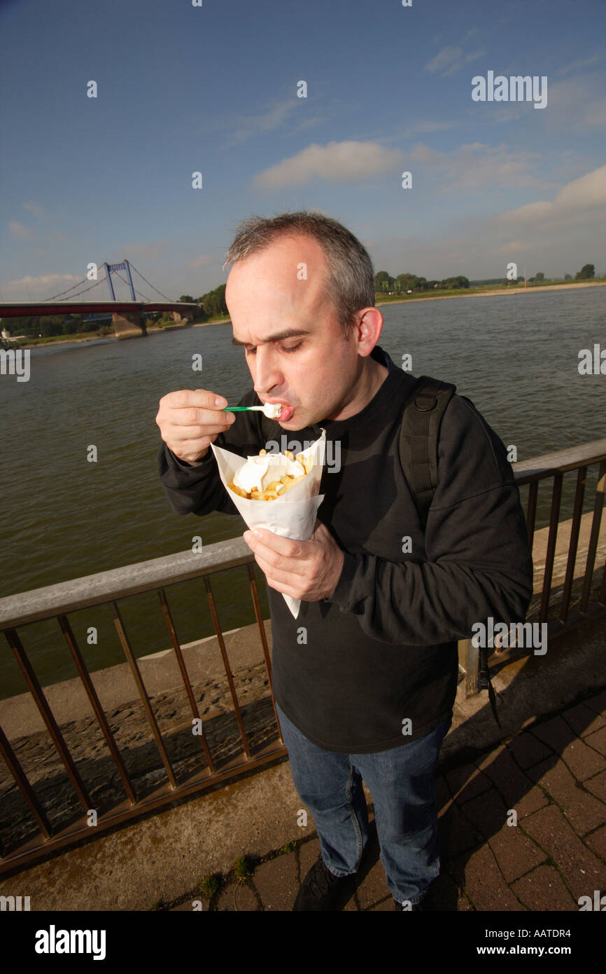 Mann isst Chips im Freien in Duisburg, Deutschland Stockfoto
