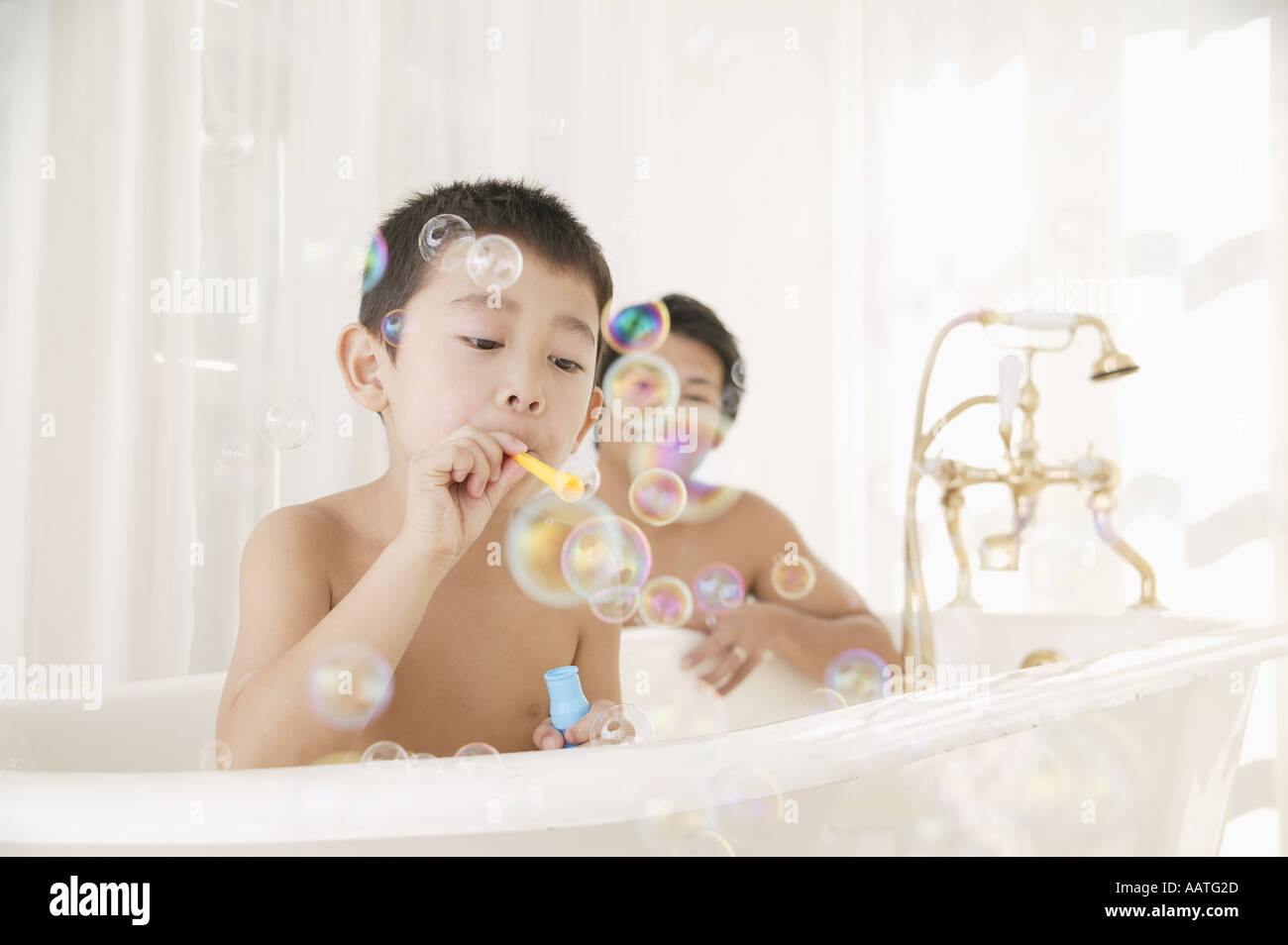 Vater und Sohn spielen mit Luftblasen im Badezimmer Stockfoto