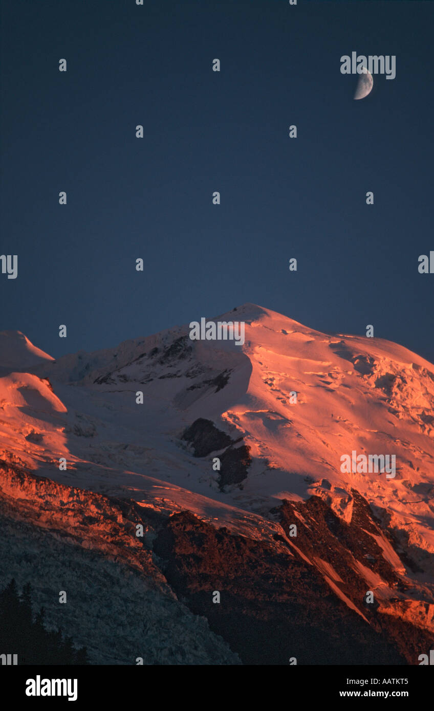 Der Mond aufgeht über den Gipfel des Mont Blanc gebadet in tief orange Licht der untergehenden Sonne, Chamonix, Frankreich Stockfoto