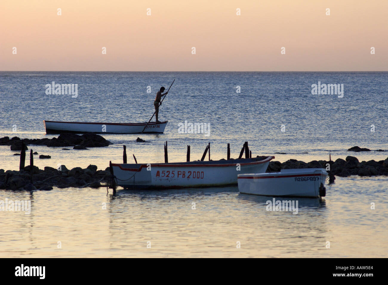 Fischer am Boot bei Sonnenuntergang Stockfoto