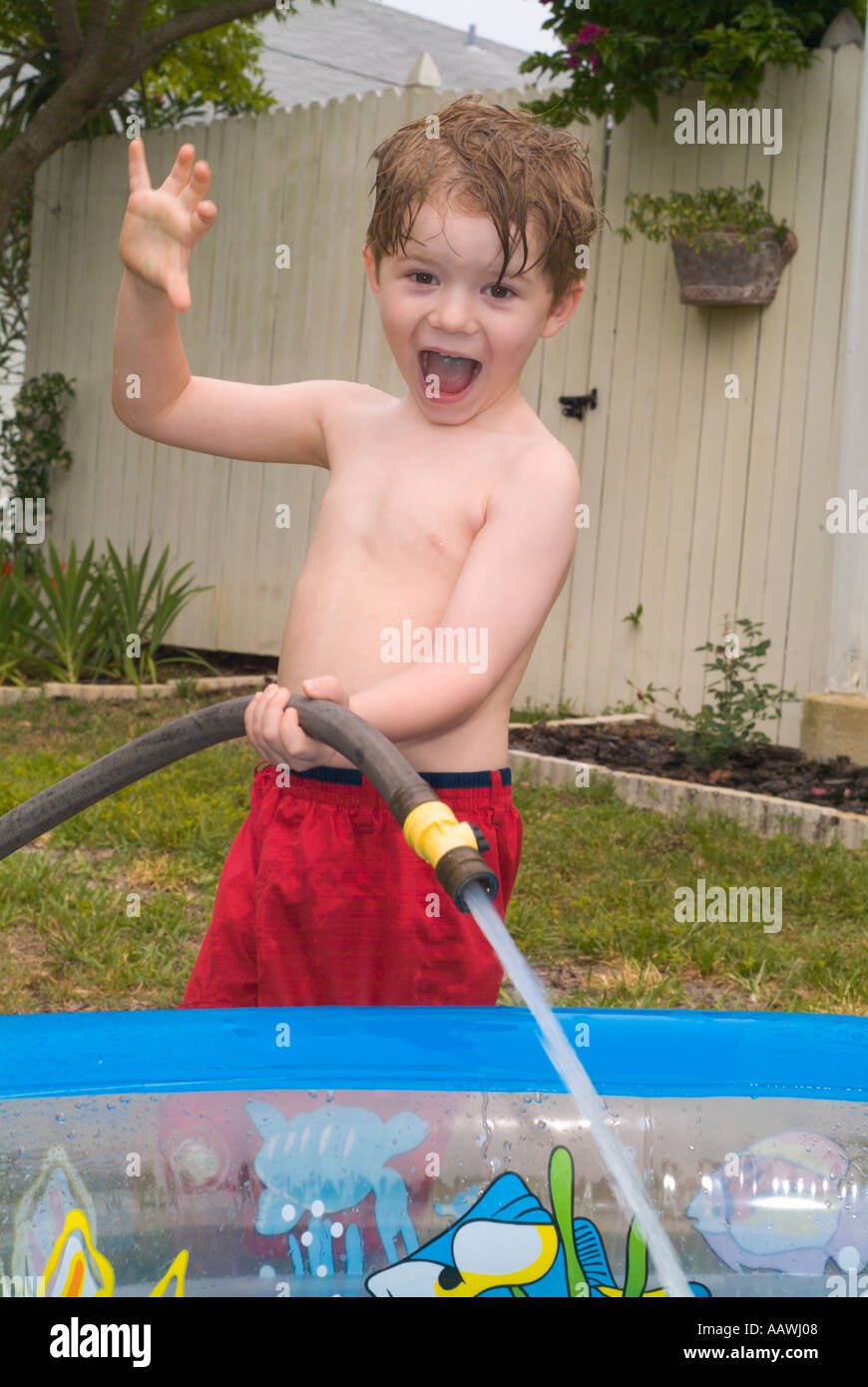 Einfüllen von Wasser Kind Kinder jungen Sommer Spielspaß nass spritzen  Schlauch Hinterhof aufgeregt Pool Boy Stockfotografie - Alamy