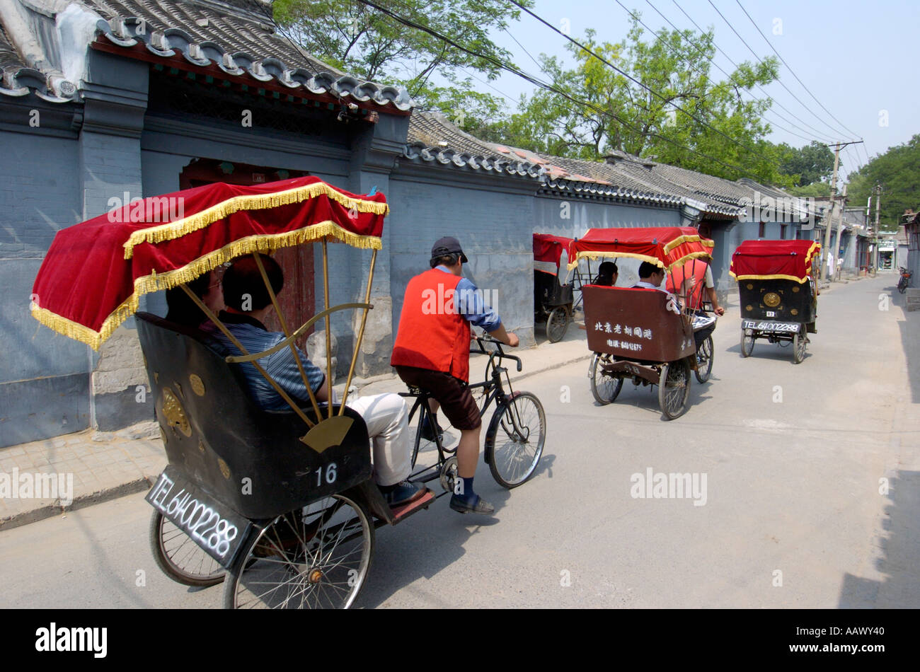 Ausländische Touristen auf eine Rikscha-Tour von Peking hutongs Stockfoto