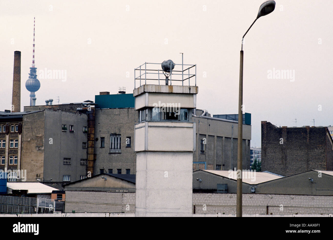 Die europäische Geschichte. Die historische Mauer und Todesstreifen Wachtturm in West Berlin in Deutschland in Europa während des Kalten Krieges. Historische Stockfoto
