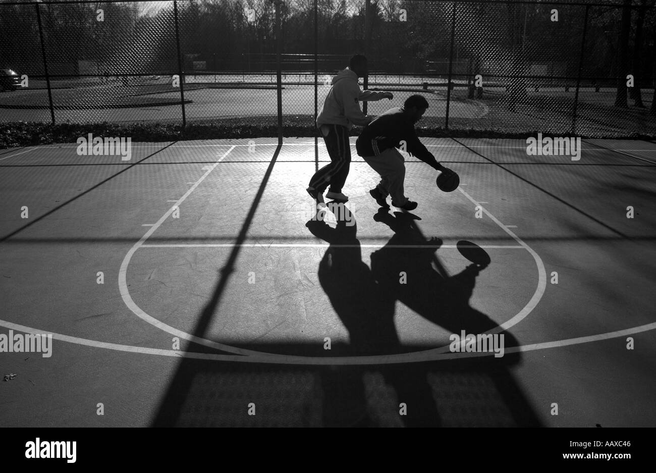 Zwei Teenager spielen Basketball im Freien auf einem Basketballfeld außerhalb Stockfoto