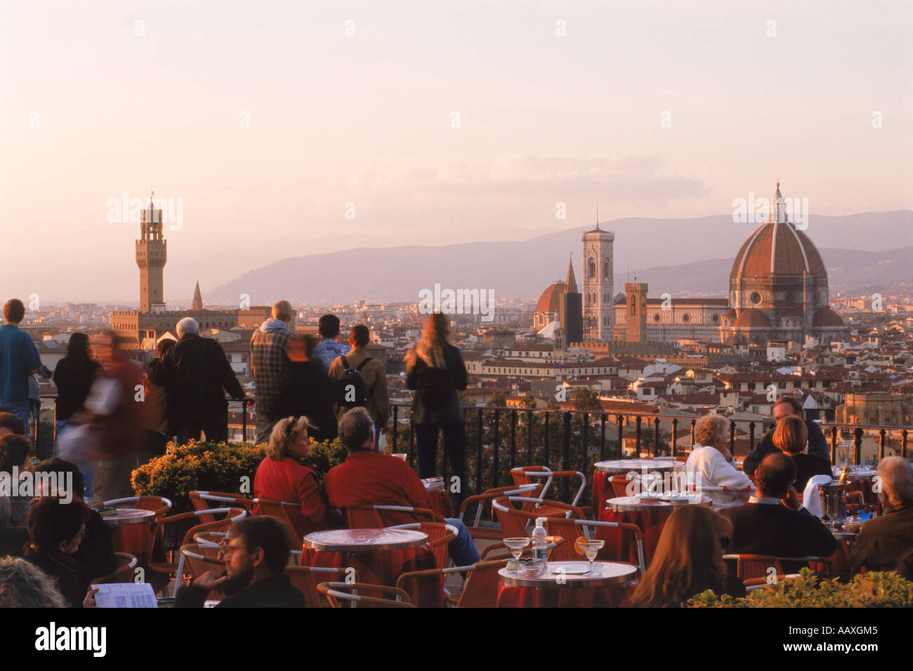 Menschen und Tabellen in Straßencafé am Piazzale Michelangelo über dem Fluss Arno und Florenz in der Nähe von sunset Stockfoto