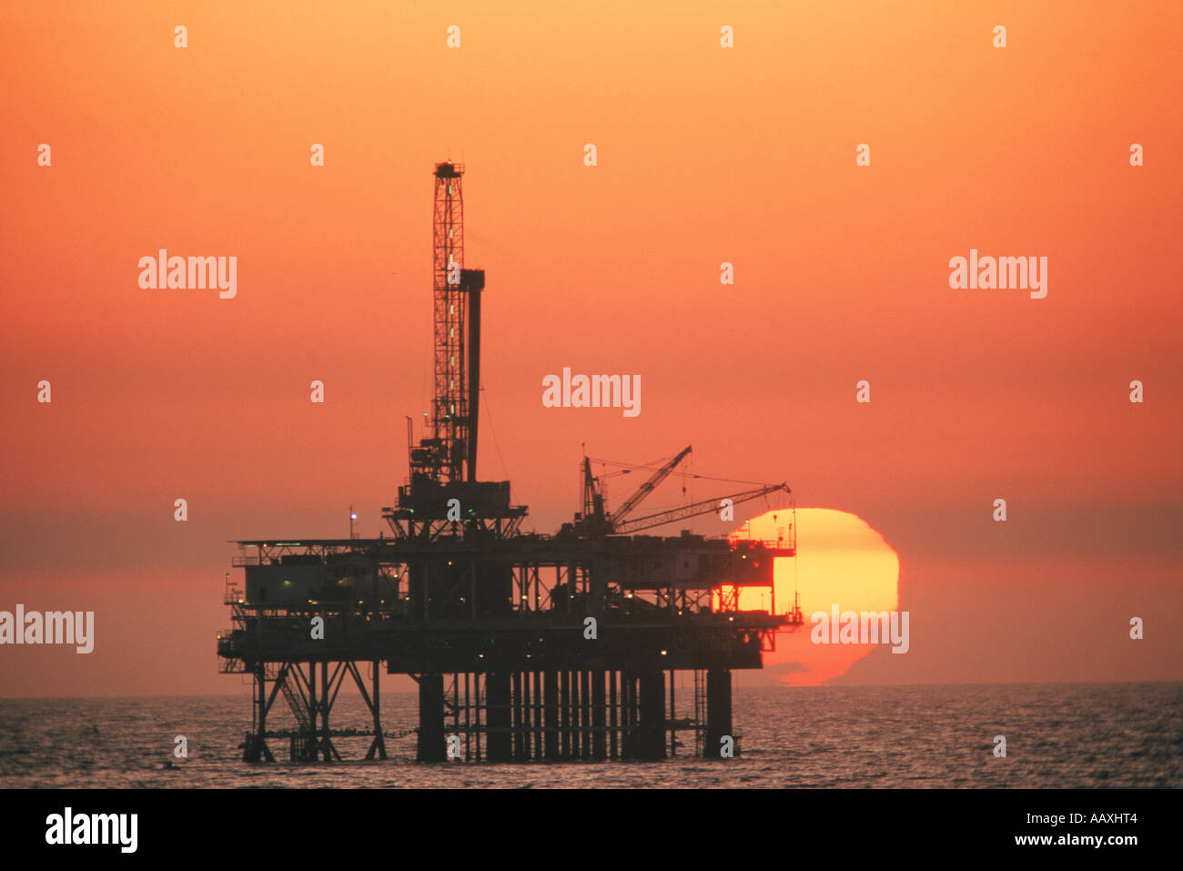 Offshore-Ölbohrplattform Silhouette bei Sonnenuntergang am Huntington Beach Kalifornien Stockfoto