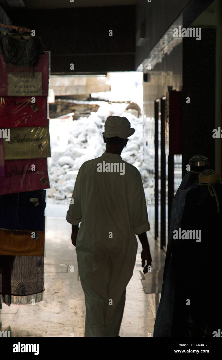 Arabische Mann zu Fuß durch die dunklen Gassen der alten Märkten Dubai Vereinigte Arabische Emirate Stockfoto