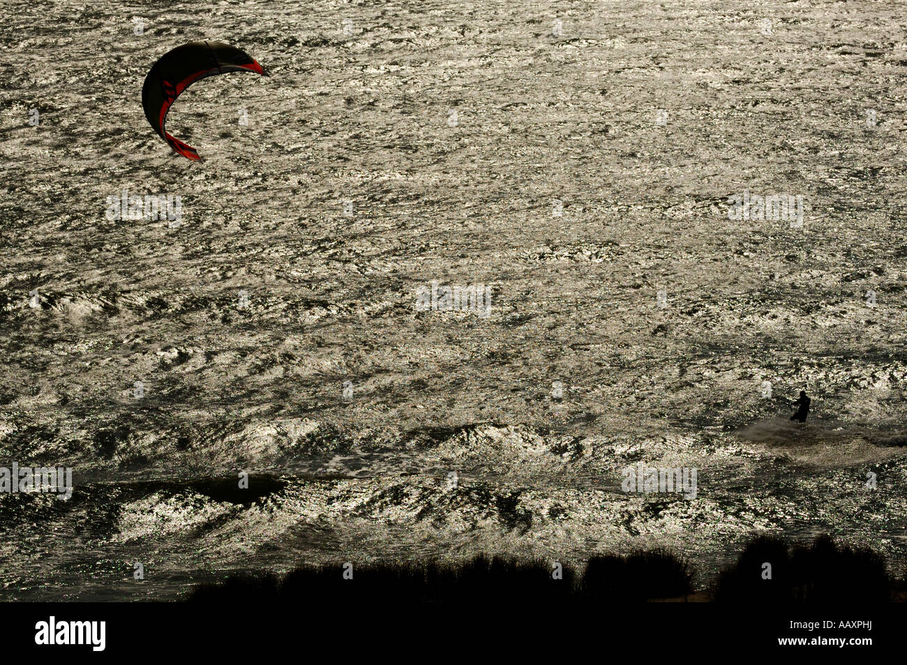 Kite-Männer auf einem schwarzen und dunklen Meer, mit Hintergrundbeleuchtung von einem Heli Ansicht/oben mit Vordergrund die Dünen Maasvlakte erschossen Stockfoto