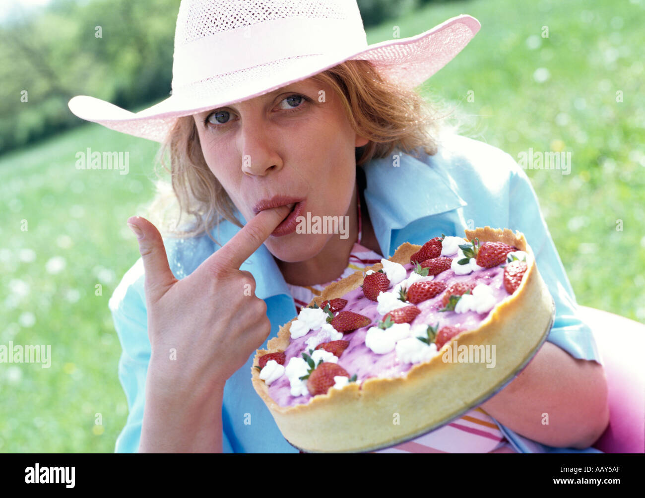 Porträt der Frau Verkostung Erdbeerkuchen Stockfoto