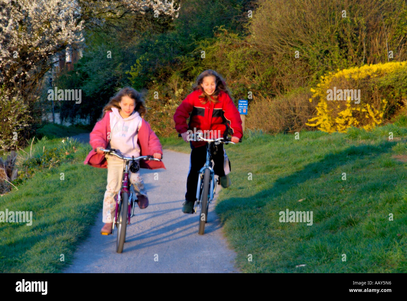 Mädchenkinder Radfahren von riverside Stockfoto