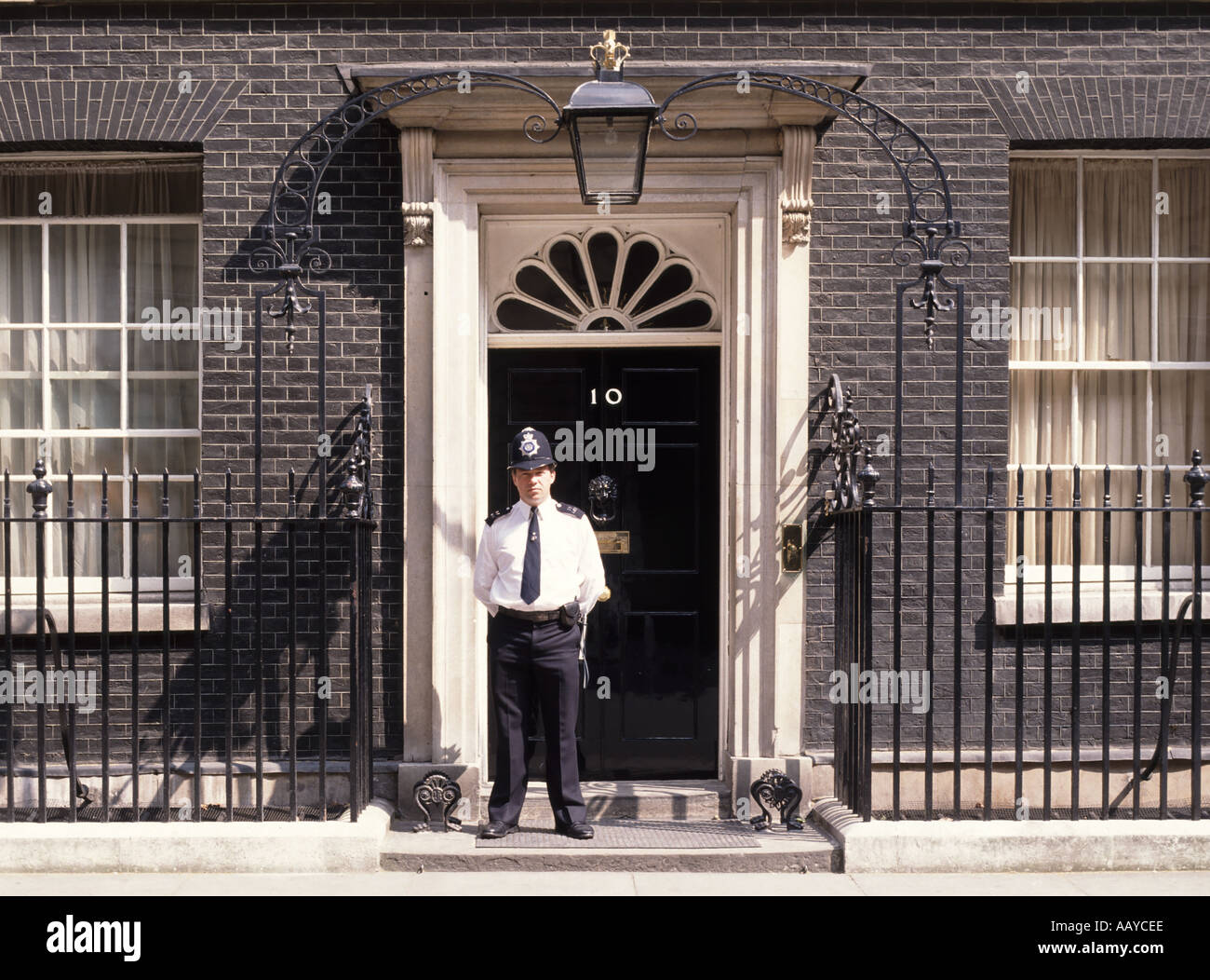 Nummer 10 Ten Downing Street Haustür und Dienst Polizeibeamter Sommer Sonnentag ohne Jacke in City of Westminster London England Stockfoto