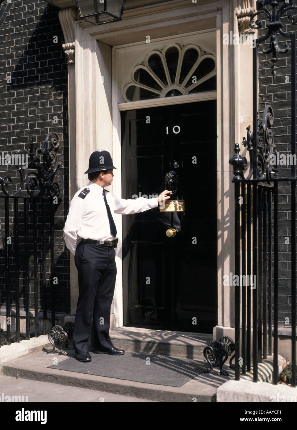 Nummer 10 Downing Street Vordertür und Pflicht Polizeioffizier klopfen an die Tür klopfen an der Tür 'Polizei' Westminster London England Großbritannien Stockfoto