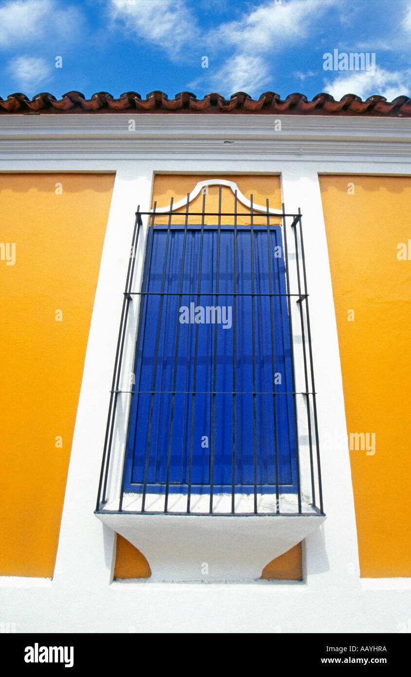 Farbenfrohe mexikanische Fenster mit blauen Fensterläden und gelben Wänden. Stockfoto