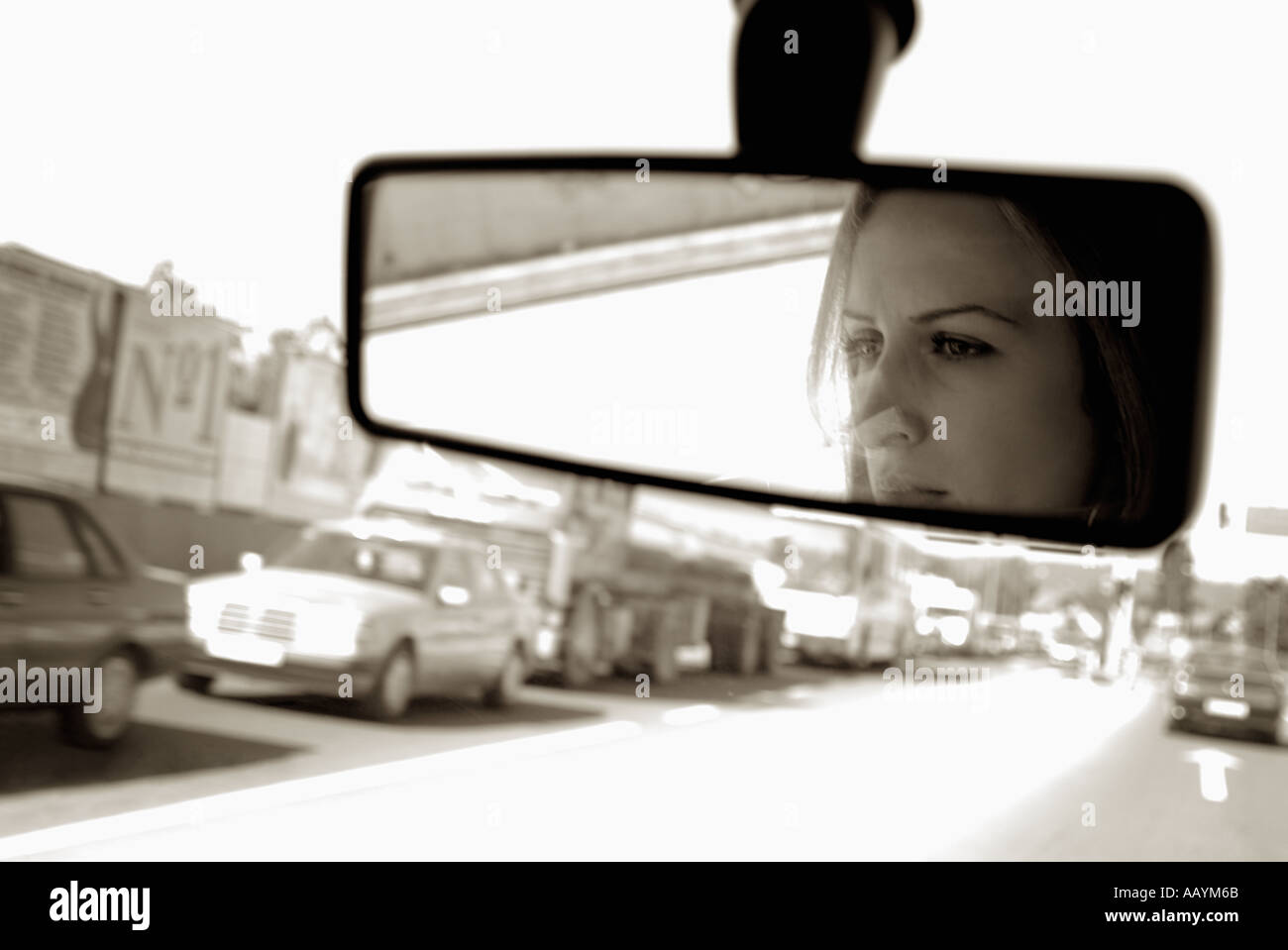 Frau im Rückspiegel eines Autos fahren in dichtem Verkehr Stockfoto