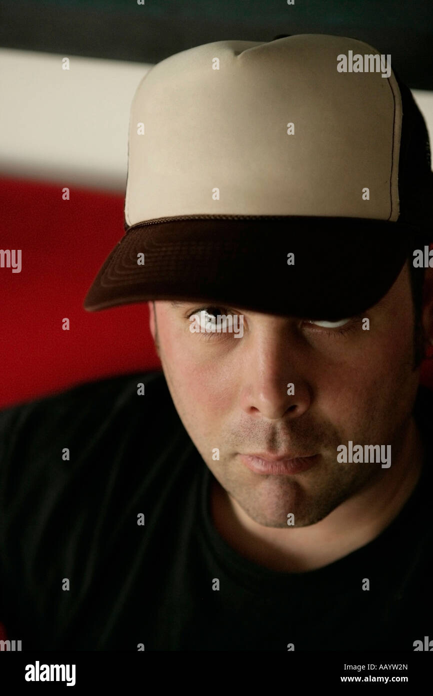 Porträt des Mannes mit Baseball-Kappe in die Kamera schaut. Stockfoto