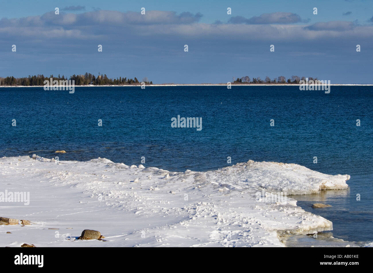 Lake Michigan Küste im Winter mit Schnee Eis und Bailey s Hafen Leuchtturm im Hintergrund Door County Wisconsin Stockfoto