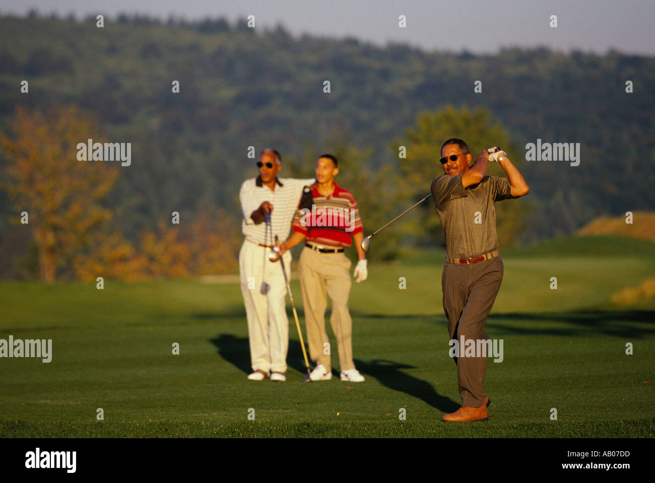 Drei Generationen von afroamerikanischen Männern Golf spielen auf einem schönen sonnigen Tag Stockfoto