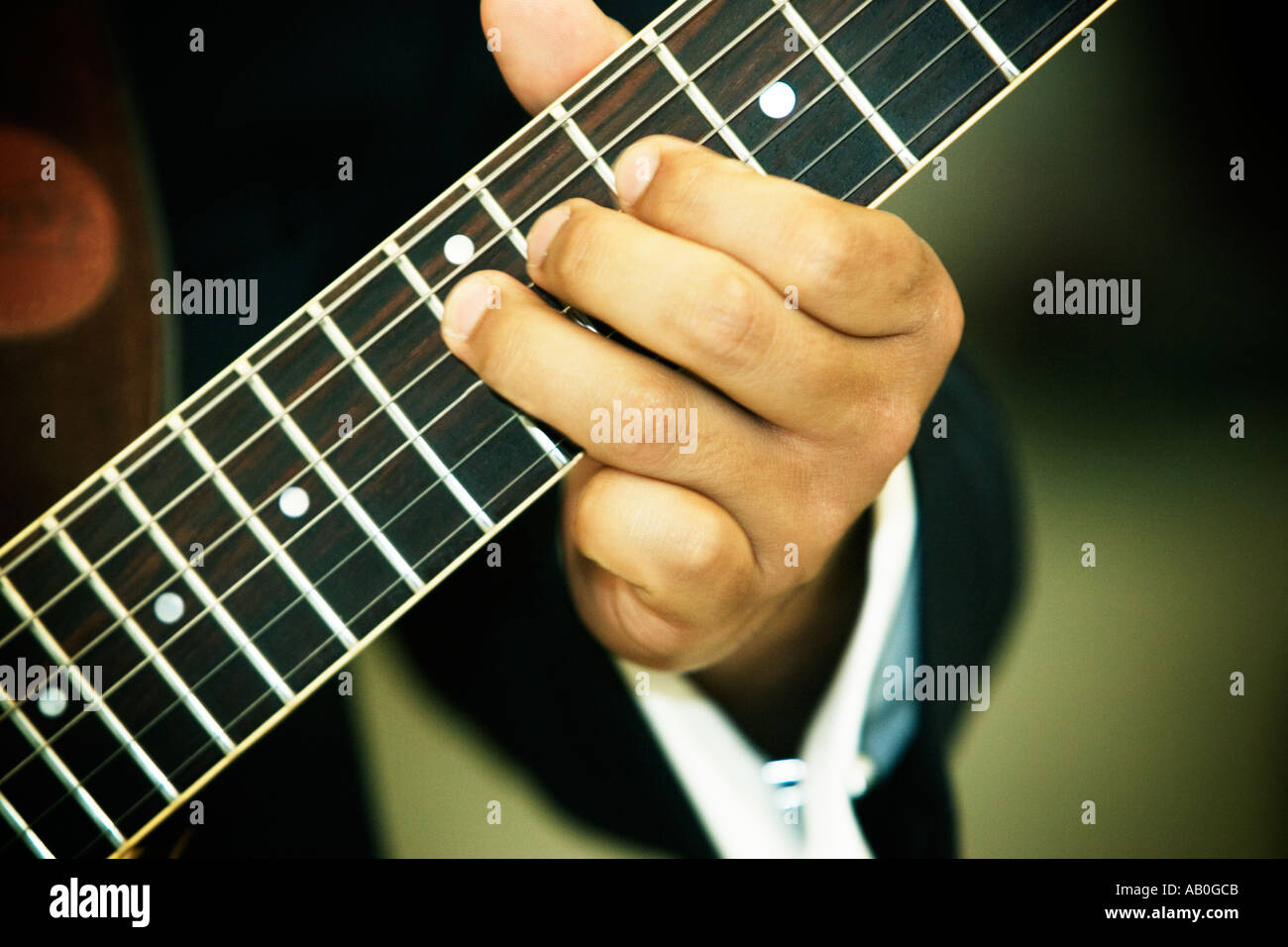Gitarristen linken Hand fressen Notizen auf dem Hals einer Gitarre Stockfoto