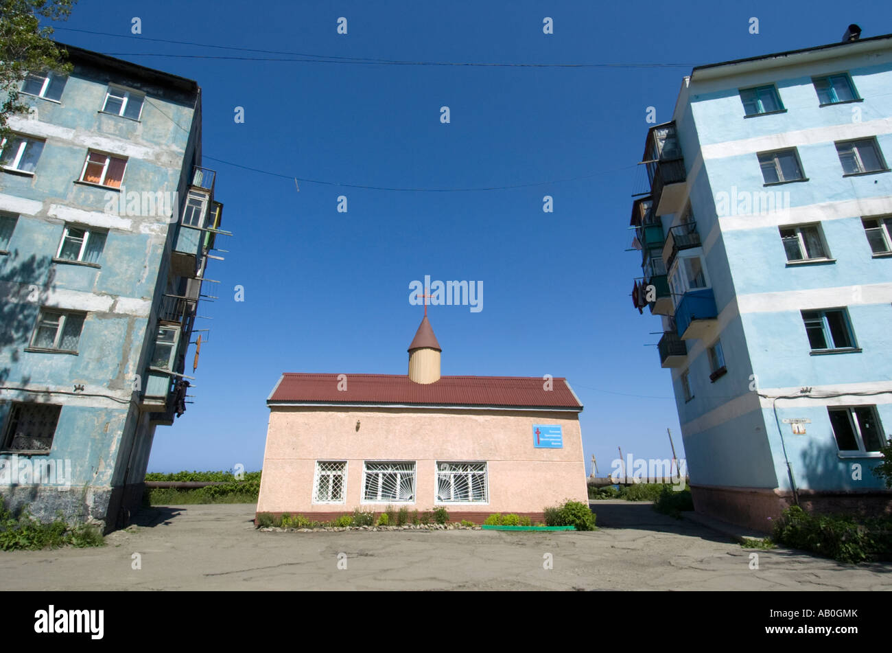 Kleinen orthodoxen Kirche erbaut zwischen konkreten Mehrfamilienhäuser in Kholmsk Sakhalin Insel Russland 2007 Stockfoto