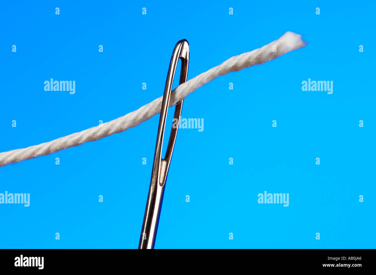 Faden Sie in ein Nadelöhr Stockfoto