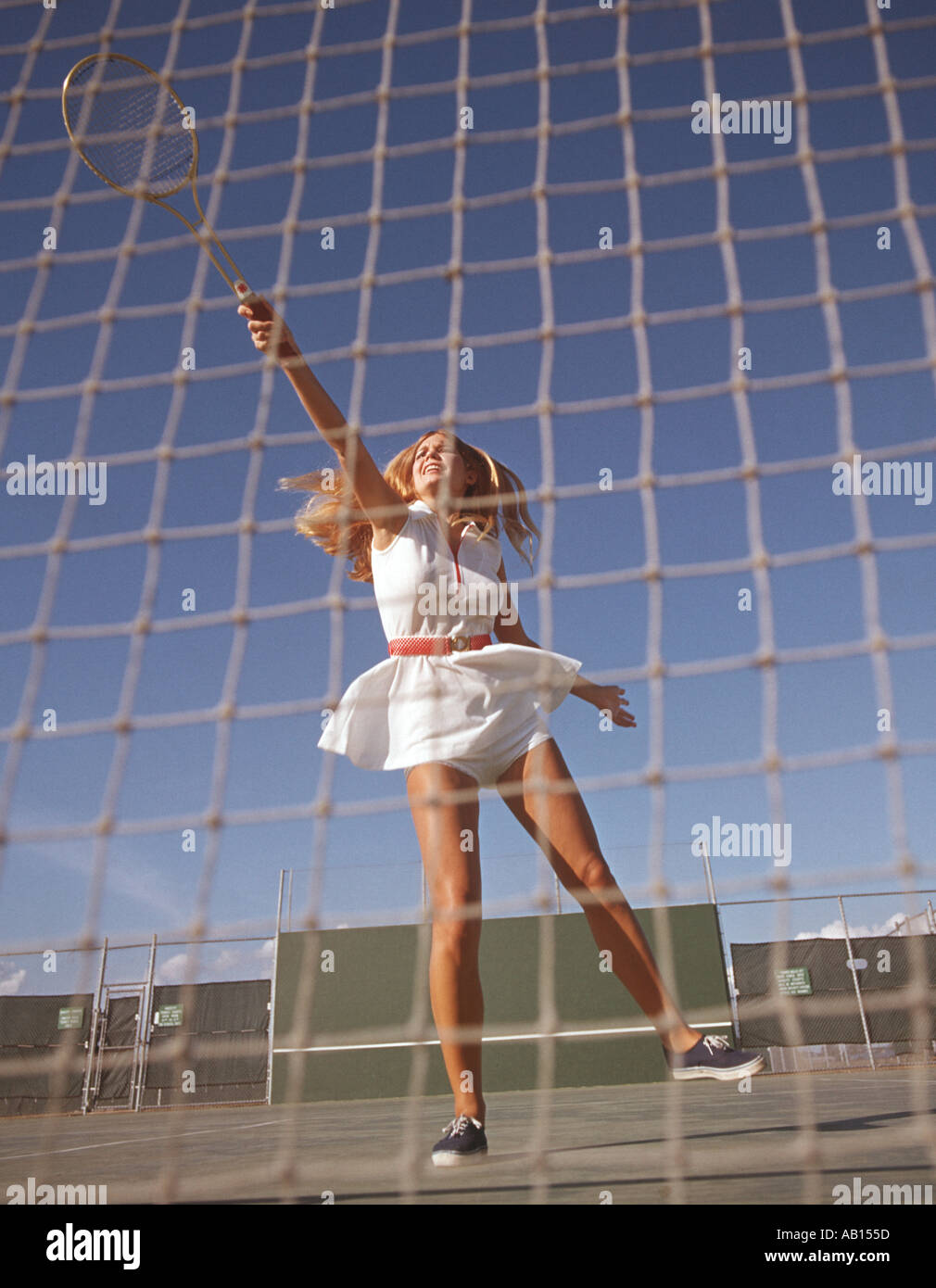 junge Frau Tennisspieler springt hoch um ein dienen zurückzukehren Stockfoto