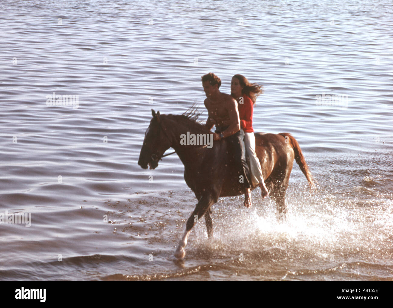 paar auf einem Pferd ohne Sattel im seichten Seewasser Stockfoto