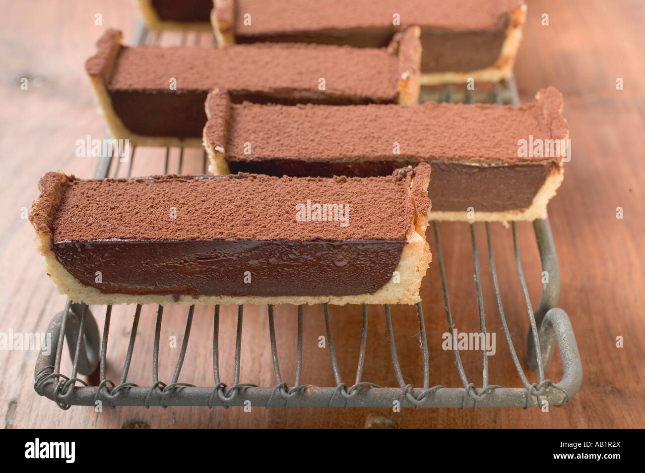 Rechteckige Schokolade Torte mit Kakaopulver in Stücken FoodCollection Stockfoto