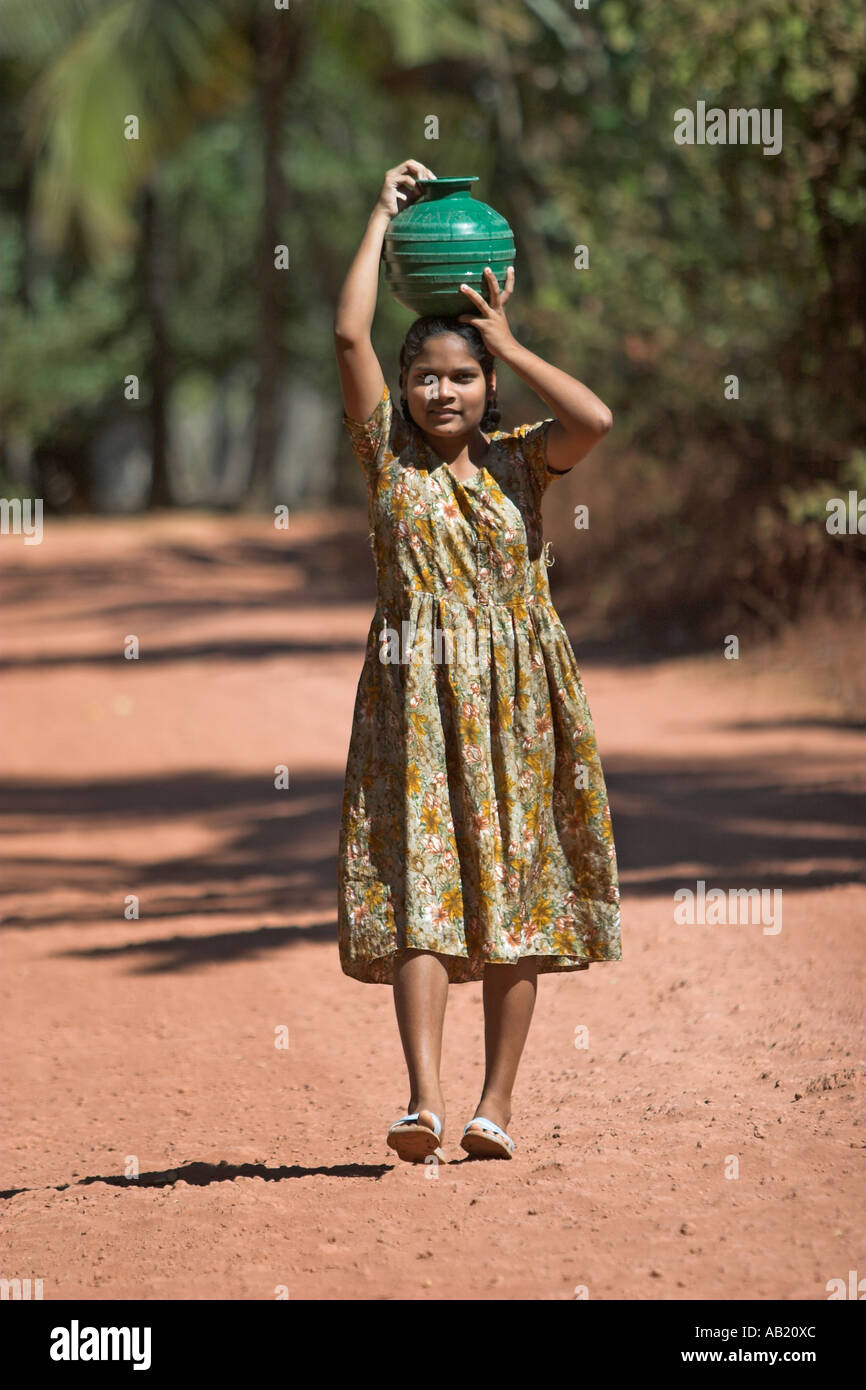 Junge Mädchen trägt grüne Wassertopf auf Kopf Mandrem Dorf Goa Stockfoto