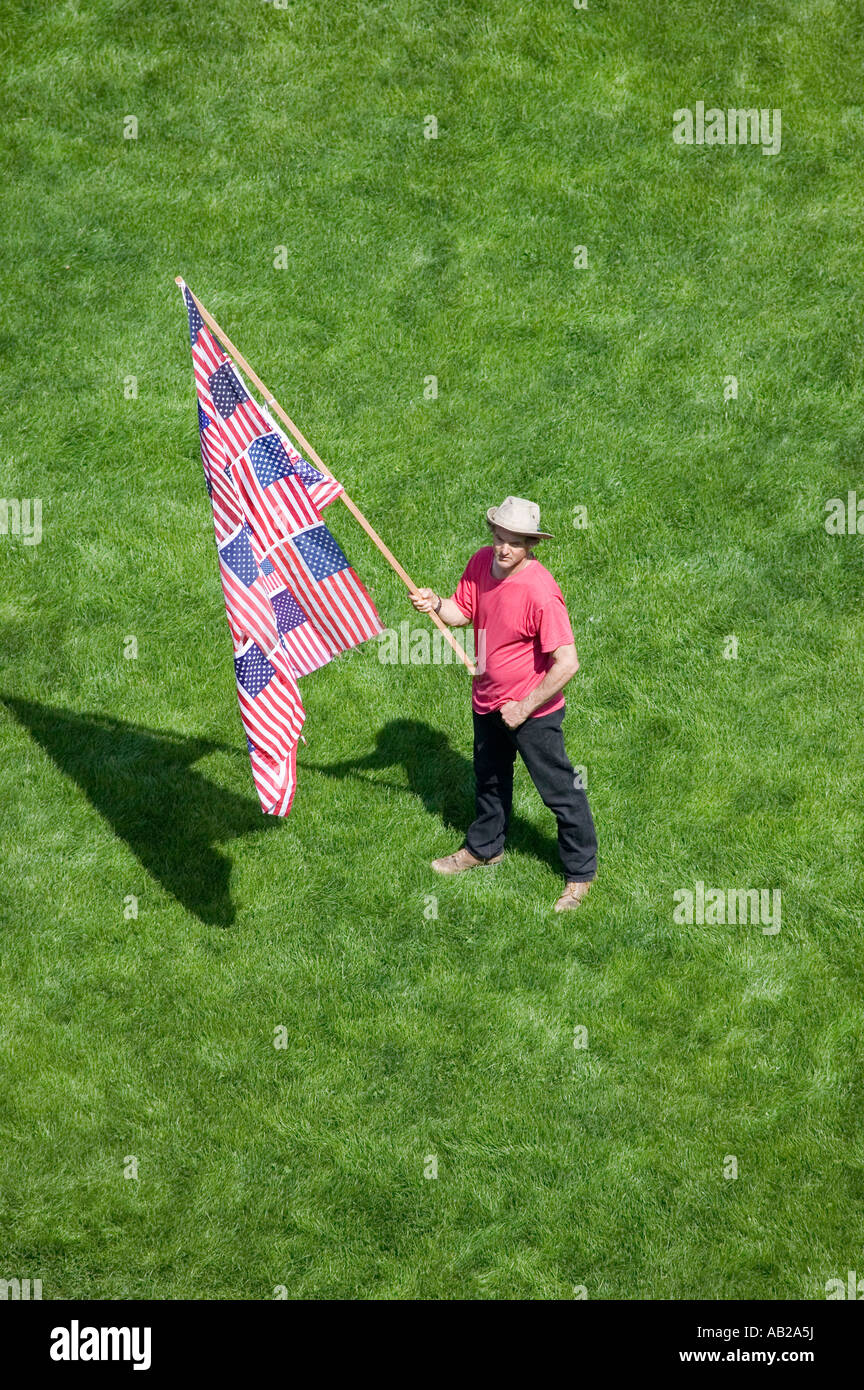 Ein patriotischer Mann mit eine US-Flagge machte viele uns Flaggen steht allein in einem grünen Rasen an einen Anti-Irak-Krieg Protestmarsch in San Stockfoto
