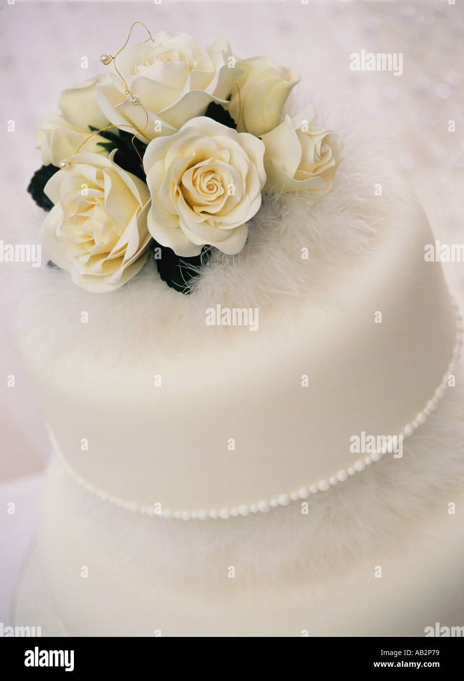 Ein weißen Kuchen Seidenrosen und Federn dekoriert Stockfoto