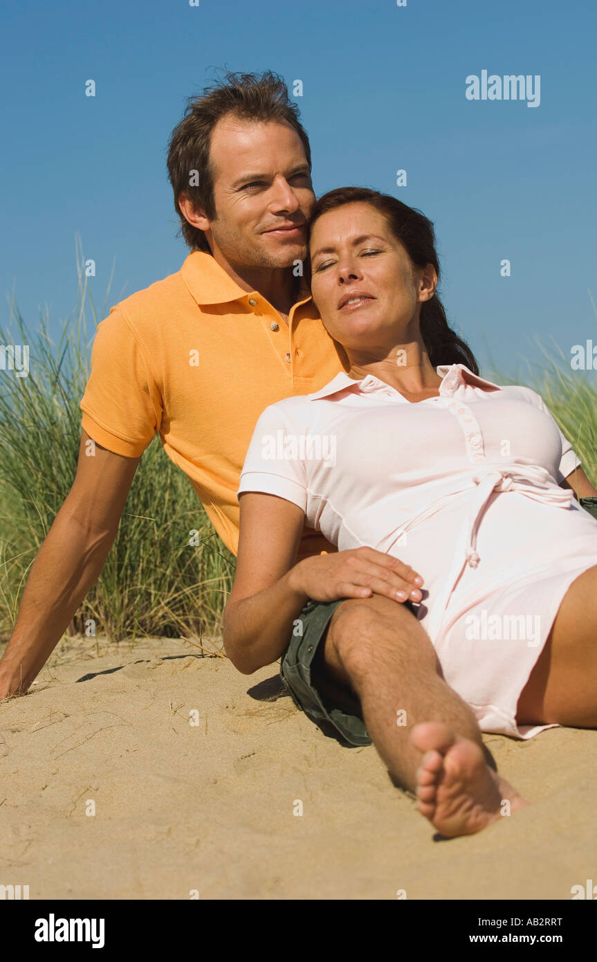 Paar sitzt am Strand Sonnenbaden Stockfoto