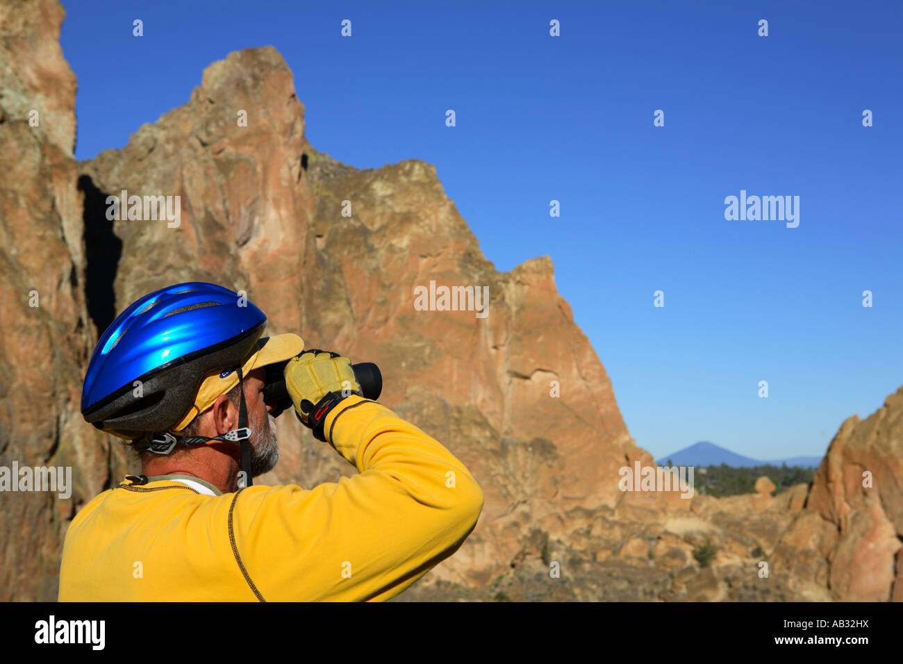 Radfahrer schaut durch ein Fernglas Smith Rock State Park-Oregon Stockfoto