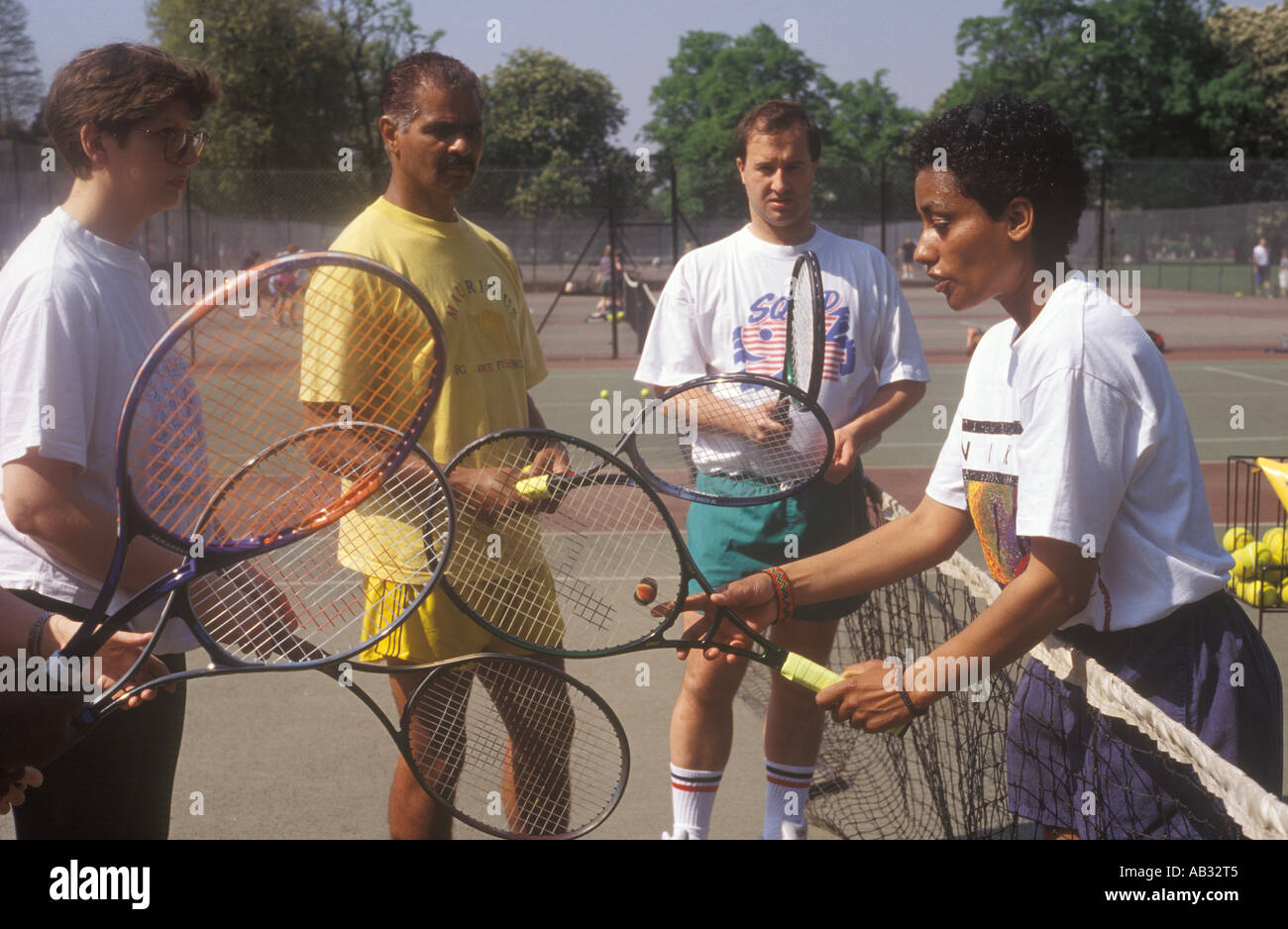 Ein Tennislehrer wird erläutert, wie einen Tennisschläger Nutzungszeit eine Tennis-Stunde für Erwachsene, Clissold Park, Stoke Newington, London, UK Stockfoto