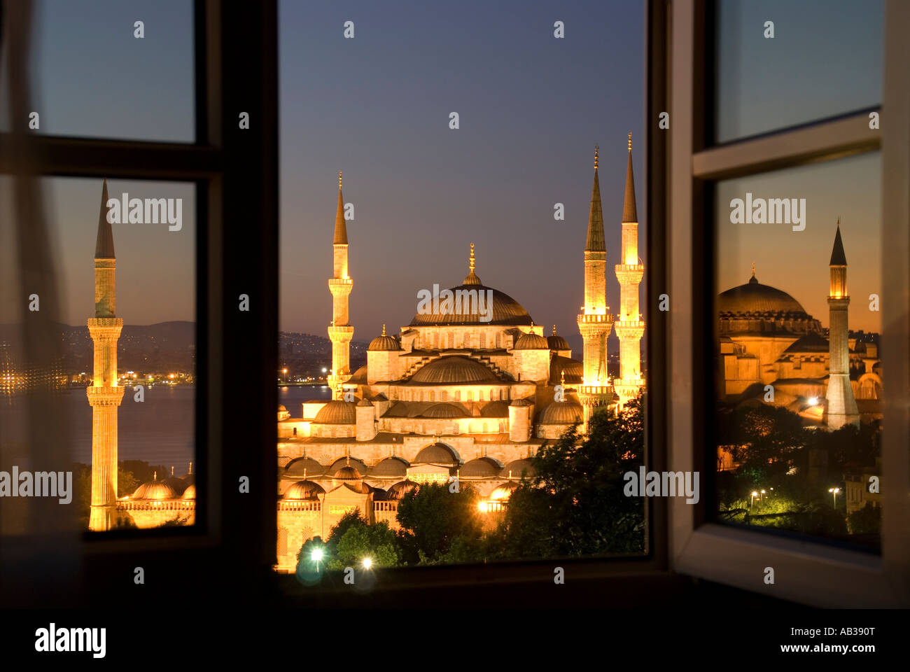 Blaue Moschee (Sultan Ahmet Cami) vom Hotelfenster im Morgengrauen mit Aya Sofya spiegelt sich im Fensterbereich auf richtige Istanbul, Türkei Stockfoto