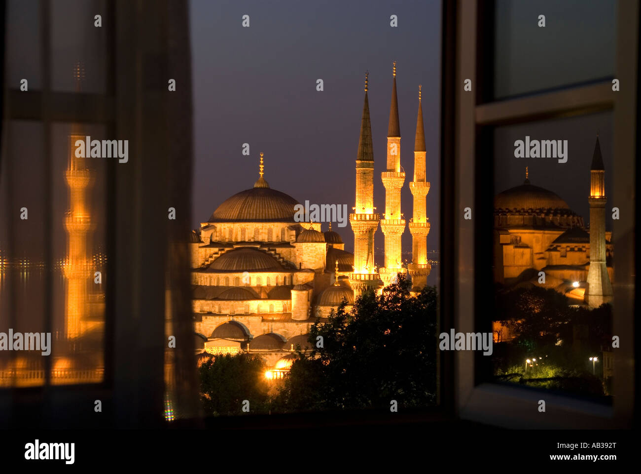 Blaue Moschee (Sultan Ahmet Cami) durch Hotelfenster im Morgengrauen mit Aya Sofya spiegelt sich im Fenster, Istanbul, Türkei Stockfoto