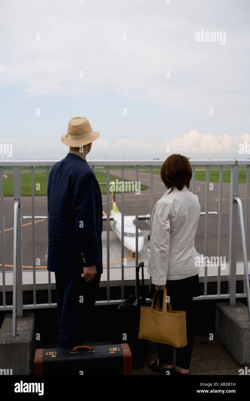 Älteres paar Blick auf Flugzeug am Flughafen Stockfoto