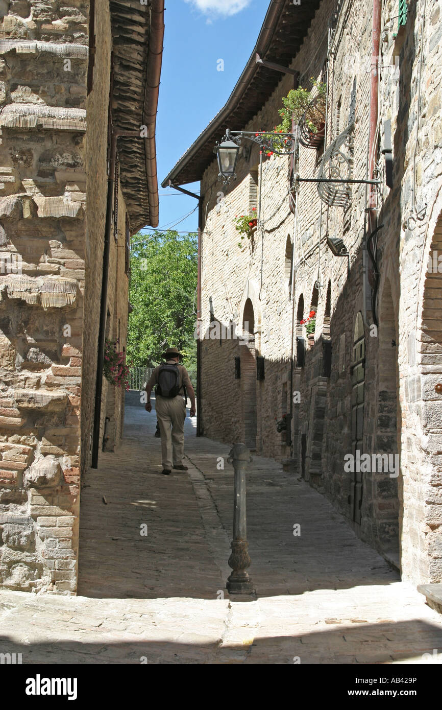 Touristen, die zu Fuß durch eine schmale Straße in Caldarola, Le Marche, Italien Stockfoto