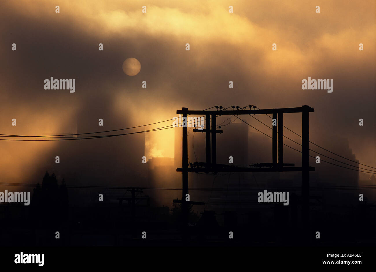 dramatischen Stadtbild zeigt Telefonmasten im Vordergrund und Sonne durch Wolken Vancouver British Columbia Kanada Stockfoto