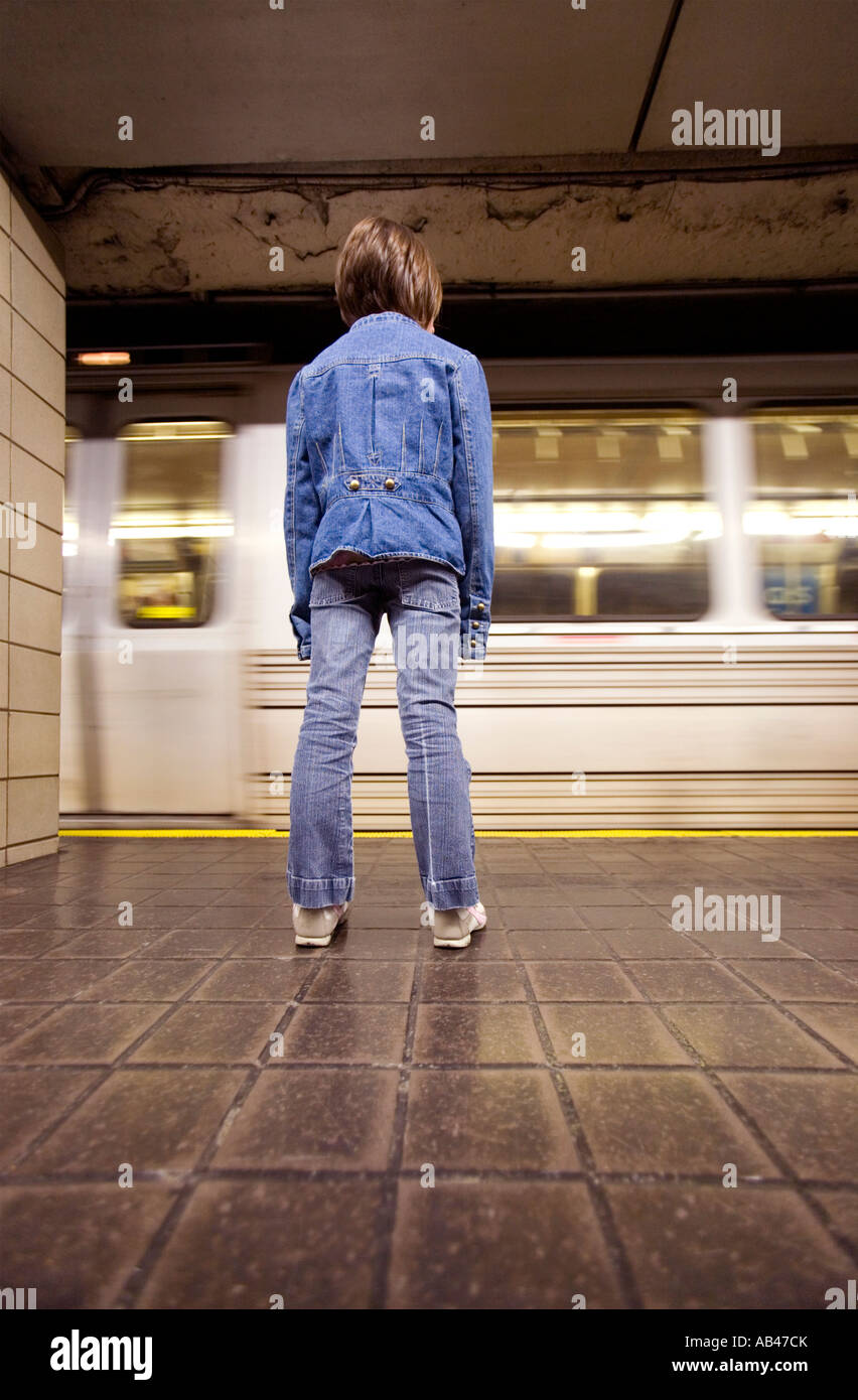 Ein junges Mädchen steht und wartet auf eine u-Bahn Stockfoto