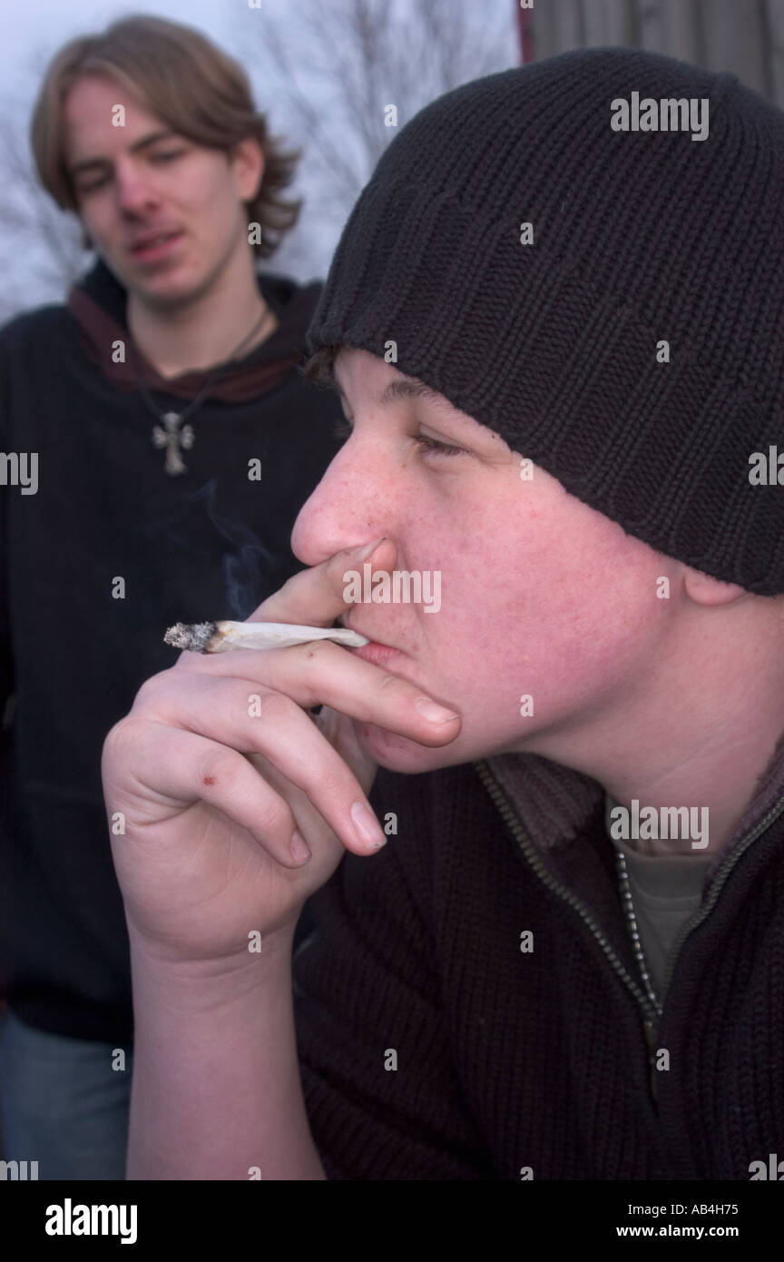 Teenager Rauchen eines Joints mit einem anderen Teenager auf der Suche auf Stockfoto